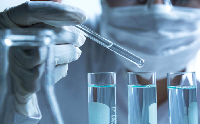 Researcher,With,Glass,Laboratory,Chemical,Test,Tubes,With,Liquid,For