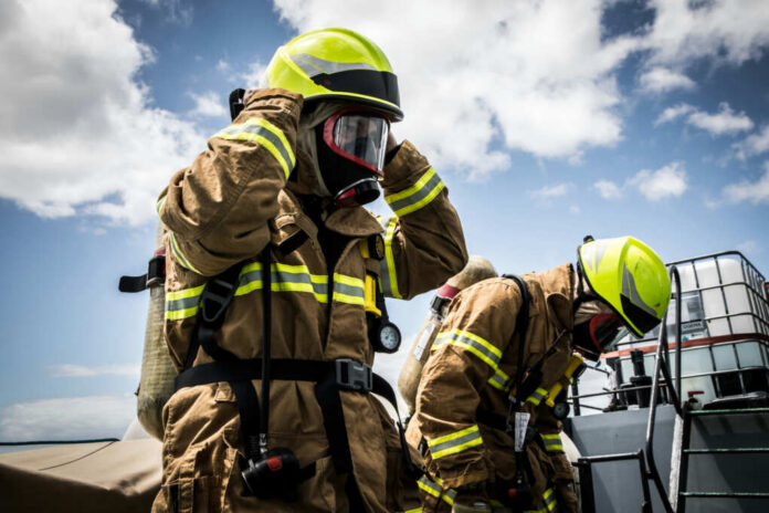firefighters-prepare2018884214jpg Firefighters in protective gear standing outside cloudy sky