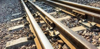 Railway tracks with rocks underneath in sunlight