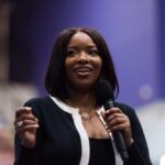 CBS Lawyer’s Call Triggered Campaign Demolition Bomb A woman speaking into a microphone with a smile