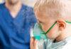Child using nebulizer mask for breathing treatment
