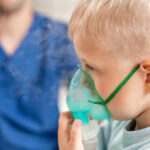 Child using nebulizer mask for breathing treatment
