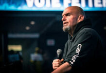 Man speaking into microphone on stage.