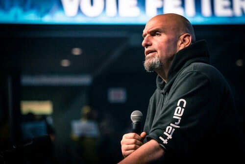 Man speaking into microphone on stage.