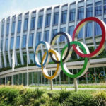 Building with Olympic rings and flags outside