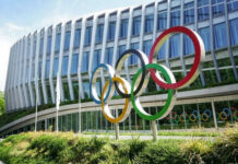 Building with Olympic rings and flags outside