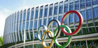 Building with Olympic rings and flags outside