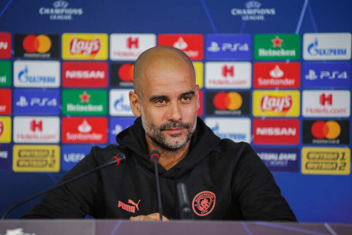 Football manager at a press conference with branding in the background