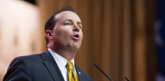 A man in a suit delivering a speech at a podium