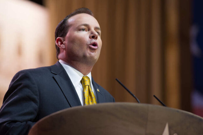 A man in a suit delivering a speech at a podium