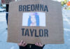 A protester holding a sign with the name Breonna Taylor and her image