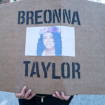 A protester holding a sign with the name Breonna Taylor and her image