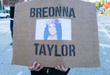 A protester holding a sign with the name Breonna Taylor and her image