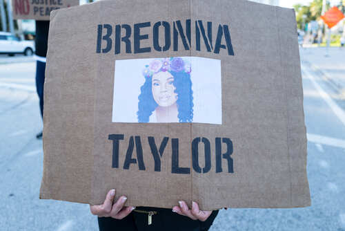 A protester holding a sign with the name Breonna Taylor and her image
