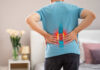 Person experiencing back pain with a visual representation of the spine