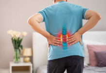 Person experiencing back pain with a visual representation of the spine