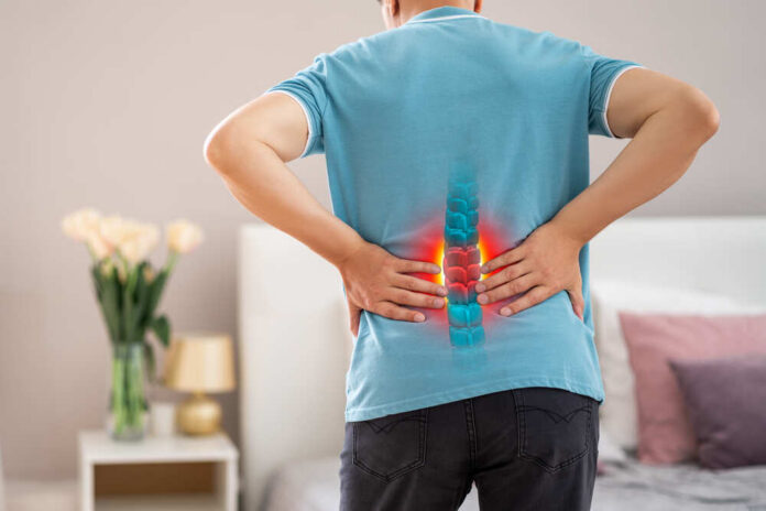 Person experiencing back pain with a visual representation of the spine