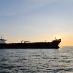 Cargo ship sailing on the ocean during sunset