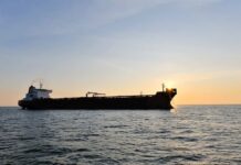 Cargo ship sailing on the ocean during sunset