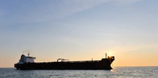 Cargo ship sailing on the ocean during sunset