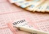 Close-up of lottery tickets and cash with a pen