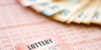 Close-up of lottery tickets and cash with a pen