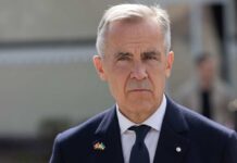 Canada, Australia Back Trump’s Bold Move A man in formal attire with a serious expression outdoors