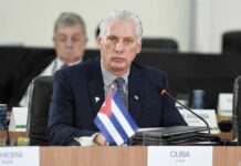 Cuban representative at a political meeting with a flag on the table