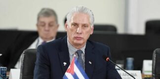 Cuban representative at a political meeting with a flag on the table