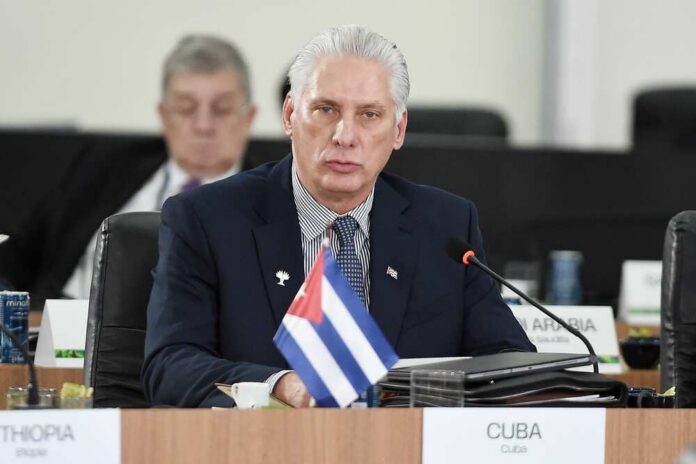 Cuban representative at a political meeting with a flag on the table