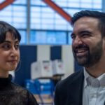 Two individuals engaged in conversation at a polling station