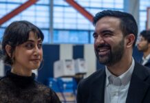 Two individuals engaged in conversation at a polling station