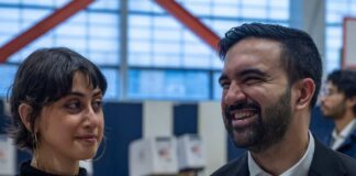 Two individuals engaged in conversation at a polling station