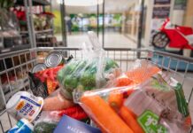 Middle East Chaos: Food Price Shock Imminent A shopping cart filled with various groceries including vegetables and canned goods