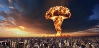 A large mushroom cloud rising over a city skyline at sunset