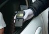 A police officer holding a breathalyzer device during a traffic stop