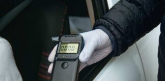 A police officer holding a breathalyzer device during a traffic stop