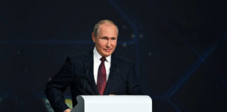 A person speaking at a podium in a suit