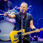 Man playing guitar and singing on stage.