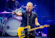 Man playing guitar and singing on stage.
