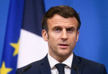 France-UK Mission Challenges US Dominance Man speaking at press conference with flags behind