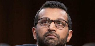 Man wearing glasses in a suit looking thoughtful