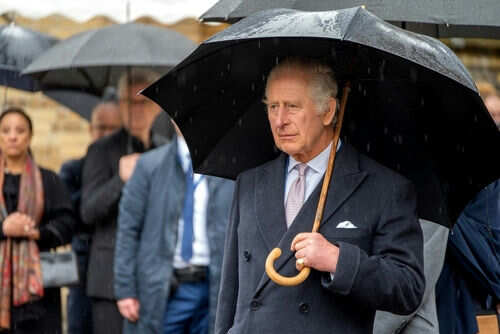 Man holding umbrella in rainy weather with crowd