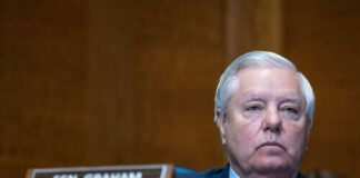 Man sitting at a desk with nameplate Sen Graham