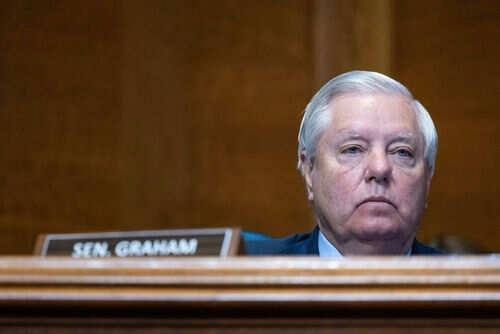 Man sitting at a desk with nameplate Sen Graham