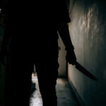 Knife Crisis: Berlin’s Hidden Crime Epidemic? Silhouette of person holding knife in dark corridor