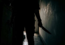 Knife Crisis: Berlin’s Hidden Crime Epidemic? Silhouette of person holding knife in dark corridor