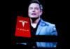 Red Tesla logo with blurred person in background