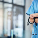Healthcare professional holding a stethoscope in hospital