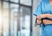 Healthcare professional holding a stethoscope in hospital